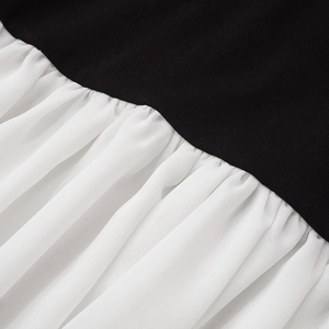 Dettaglio del tessuto in maglia nera e della cucitura a contrasto in chiffon pieghettato