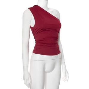 Detail of burgundy one-shoulder top showing pleated side ruffles and slim fit fabric