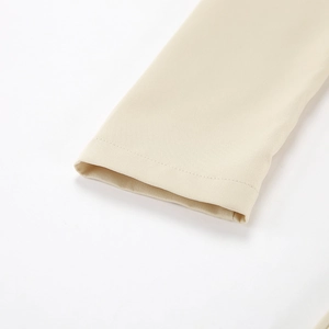 Close-up of cuff detail on the beige irregular neck split dress with woven texture