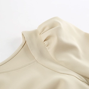 Detail of elegant puffed sleeve and textured fabric on khaki midi dress