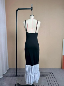 Dettaglio dell'abito aderente nero con balze in chiffon bianco a contrasto sull'orlo