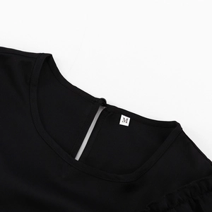 Close-up of the round neckline with button closure and M size tag on black dress