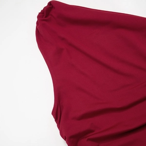 Close-up of the smooth dark red fabric texture and draped off-shoulder detail on the top