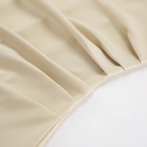 Detailed macro view of the pleated texture and dense knit fabric on a khaki dress