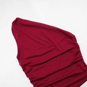 Detail of burgundy one-shoulder top showing ruched side texture and elastic knit fabric