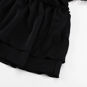 Close-up of black chiffon dress layers with delicate white lace trim and ruffles