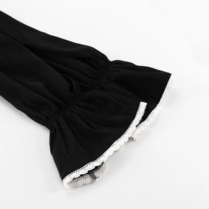 Detail of flared cuffs with elegant white lace trim on a minimalist black dress