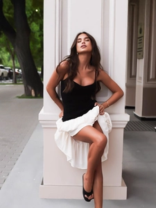 Elegante top a canotta nero con gonna aderente bianca a balze per un look casual