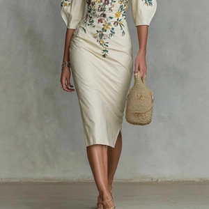 Détail d'une élégante robe midi beige à épaules dénudées avec broderie florale