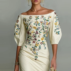 Détail de l'encolure bustier et des broderies florales sur la robe ivoire ajustée