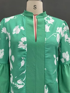 Detail of green floral dress featuring V-neckline and elegant bell sleeves fabric