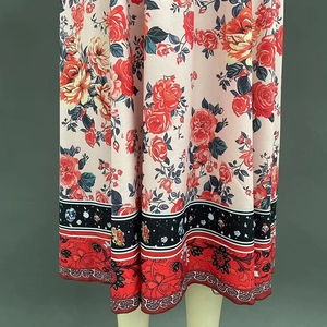 Vue détaillée de l'ourlet de robe bohème avec motifs roses et bordure céleste décorative