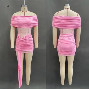 Detail of pink off-shoulder mini dress featuring mesh lace panels and ruched fabric