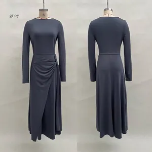 Detail of the elegant knot waist and wrapped skirt design on a grey long-sleeved dress