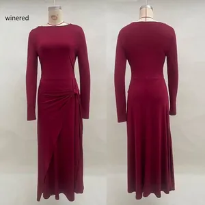 Detail of elegant wine red long sleeve dress featuring side knot ruching and high slit cut