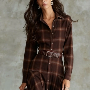 Detail of vintage plaid shirt dress with embossed brown leather belt and textured fabric