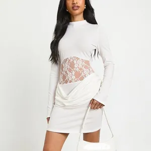 Detail of white slim-fit dress featuring floral lace cutout waist and ruched hem design