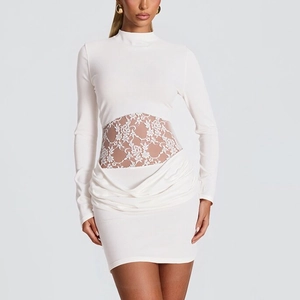 Detail of white long sleeve dress showing lace waist patchwork and draped ruched hem