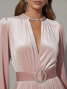 Detail of velvet dress with pleated fabric, deep V-neck, and rhinestone buckle belt