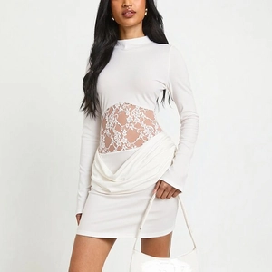 Detailed view of the white long sleeve mini dress featuring lace waist cutouts and pleats