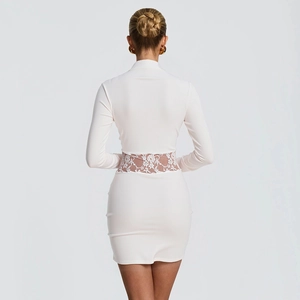 Detail view of intricate floral lace patchwork on the waist of a white bodycon mini dress