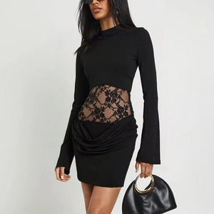 Detail of black long sleeve dress featuring floral lace waist cutout and ruched hem detail