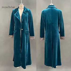 Detail view showing royal blue velvet coat with leopard print cuffs and gold button closure