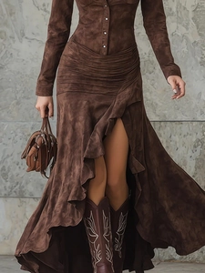 Detailed texture of brown suede dress with pleated waist and asymmetrical ruffle hem