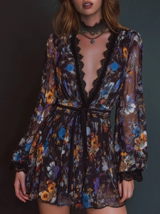Macro detail of the deep V-neckline with delicate black eyelash lace and floral patterns