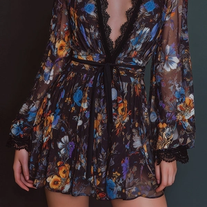 Close-up of V-neck floral organza dress showing black lace trim and delicate waist tie