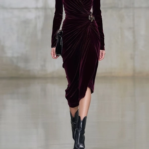 Detailed close-up of the pleated waist design and vintage brooch on a velvet dress