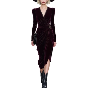 Detailed close-up of velvet dress featuring deep V-neck with black trim and side ruching