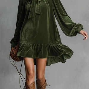 Détail d'une mini-robe en velours vert foncé à manches longues avec nœud au col