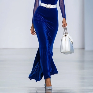 Elegant deep blue velvet long-sleeve dress with white rhinestone belt and luxury handbag
