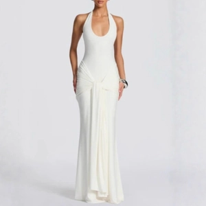 Detailed close-up of fan-shaped pleated draping on white halter neck evening maxi dress