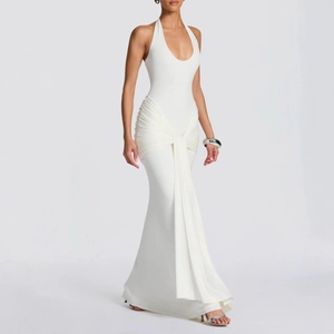 Detail of elegant white halter neck dress featuring pleated waist and flowing ribbon drape