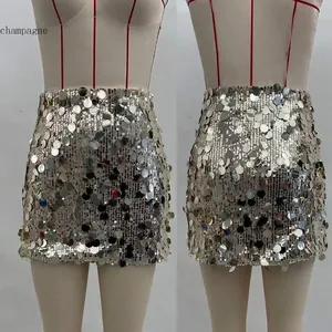 Close-up of champagne mini skirt with large sequins showing reflective metallic texture