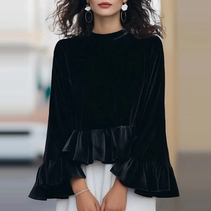 Détail du sweat en velours noir avec volants à la taille et aux poignets sur modèle