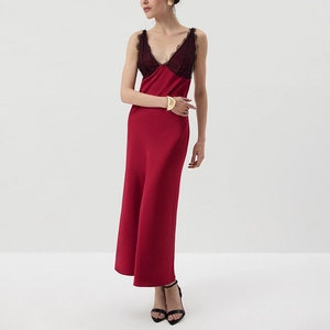 Detail of elegant red satin dress featuring intricate black lace trim on the V-neckline
