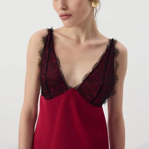 Close-up of deep red satin dress featuring a V-neckline with black eyelash lace trim