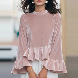 Détail du haut en velours rose avec poignets à volants et texture brillante
