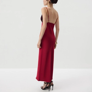 Close-up of red satin dress featuring black lace trim and low back design detail