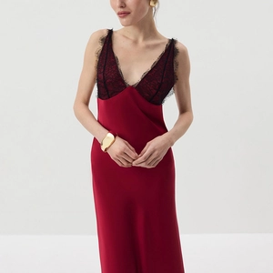 Detail of red silk dress featuring black eyelash lace patchwork and elegant V-neck design