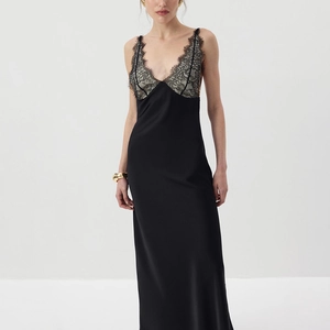 Detail of elegant black lace neckline and silk-like fabric on a bodycon slip dress