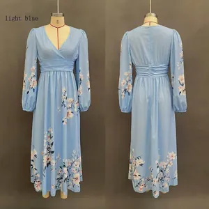 Detailed view of light blue V-neck dress with pink floral patterns and long elastic sleeves