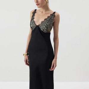 Detail of delicate grey lace patchwork and V-neckline on a black satin bodycon dress
