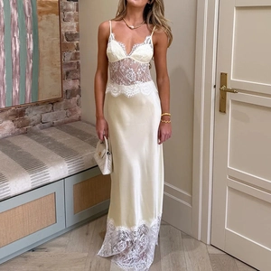 Détails de dentelle blanche et tissu satiné sur une robe longue dos nu de couleur crème