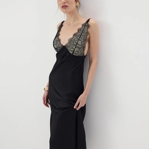 Close-up of elegant black silk dress featuring intricate grey eyelash lace trim at neckline