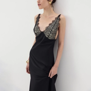 Detail of elegant black satin slip dress featuring V-neckline with delicate lace trim