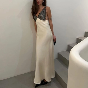 Detailed close-up of ivory satin maxi dress featuring intricate black lace拼接 at the bust